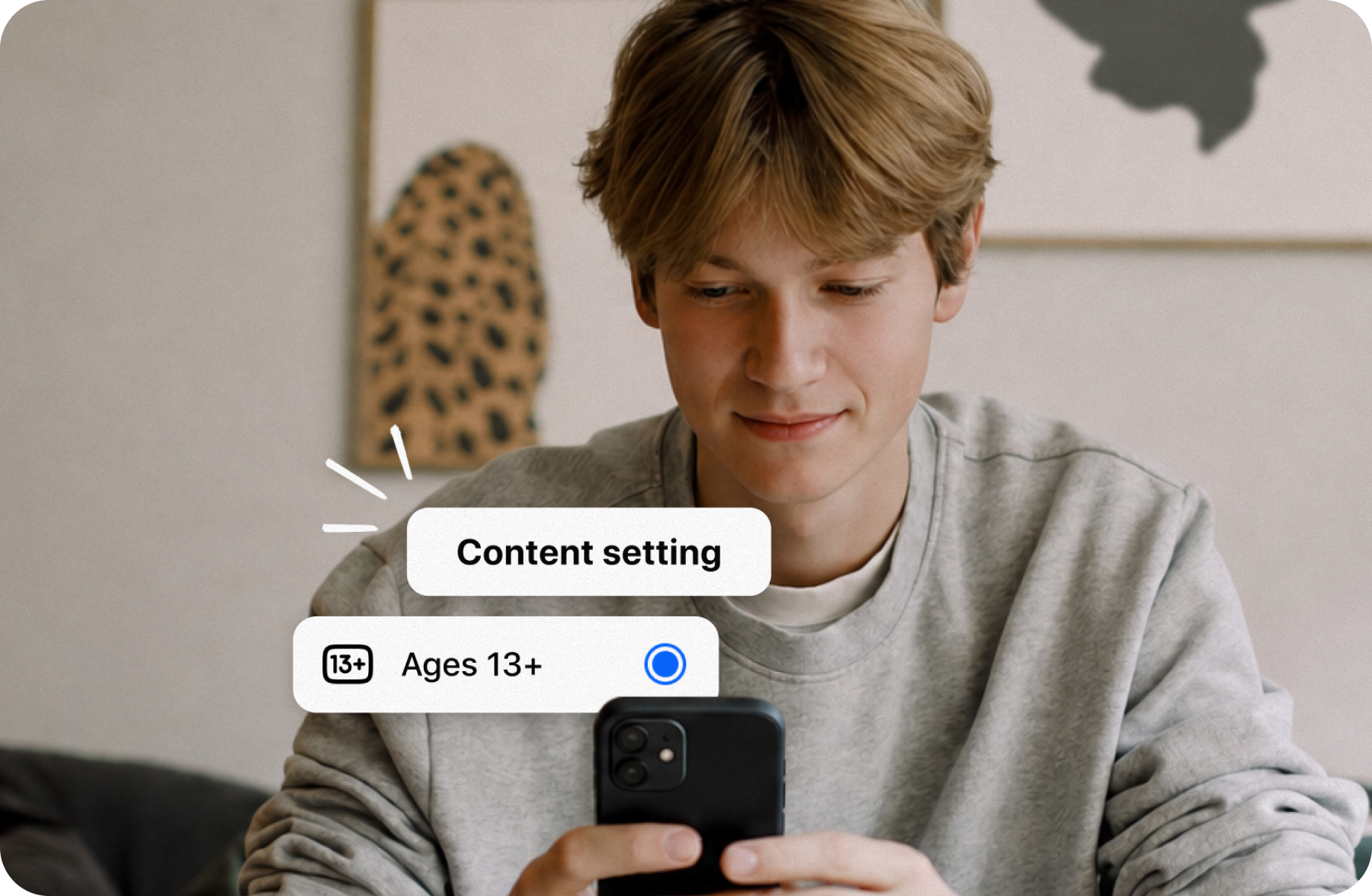 A teen looking at a phone showing a content setting toggle set to Ages 13+